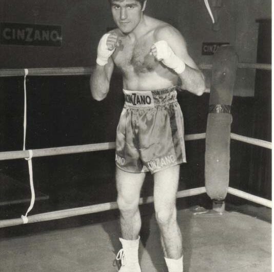 Ritratto di Nino Benvenuti, leggendario pugile italiano e campione olimpico a Roma '60, che esprime determinazione e passione, simbolo di una carriera che ha ispirato lo sport nazionale.